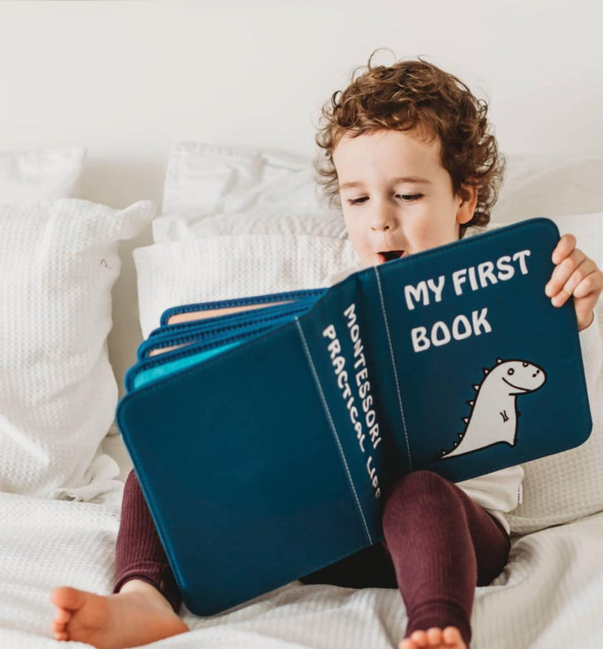 Kind spielt mit einem My First Book Quiet Book